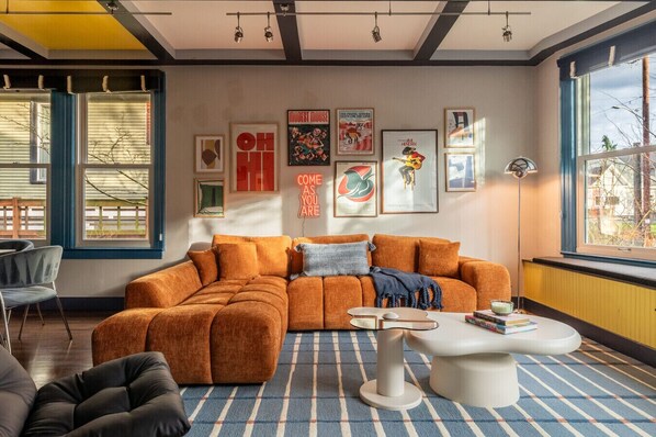 A modern living room with a sectional sofa, a coffee table, and a large window with a view.