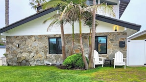 A modern house with stone exterior walls, two windows, and a white door. - Walk to the beach, CURATED 1-bedroom guesthouse, KING BED, EV charger (Huntington Beach)