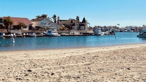 A beach with a marina, houses, and boats. - Walk to the beach, CURATED 1-bedroom guesthouse, KING BED, EV charger (Huntington Beach)