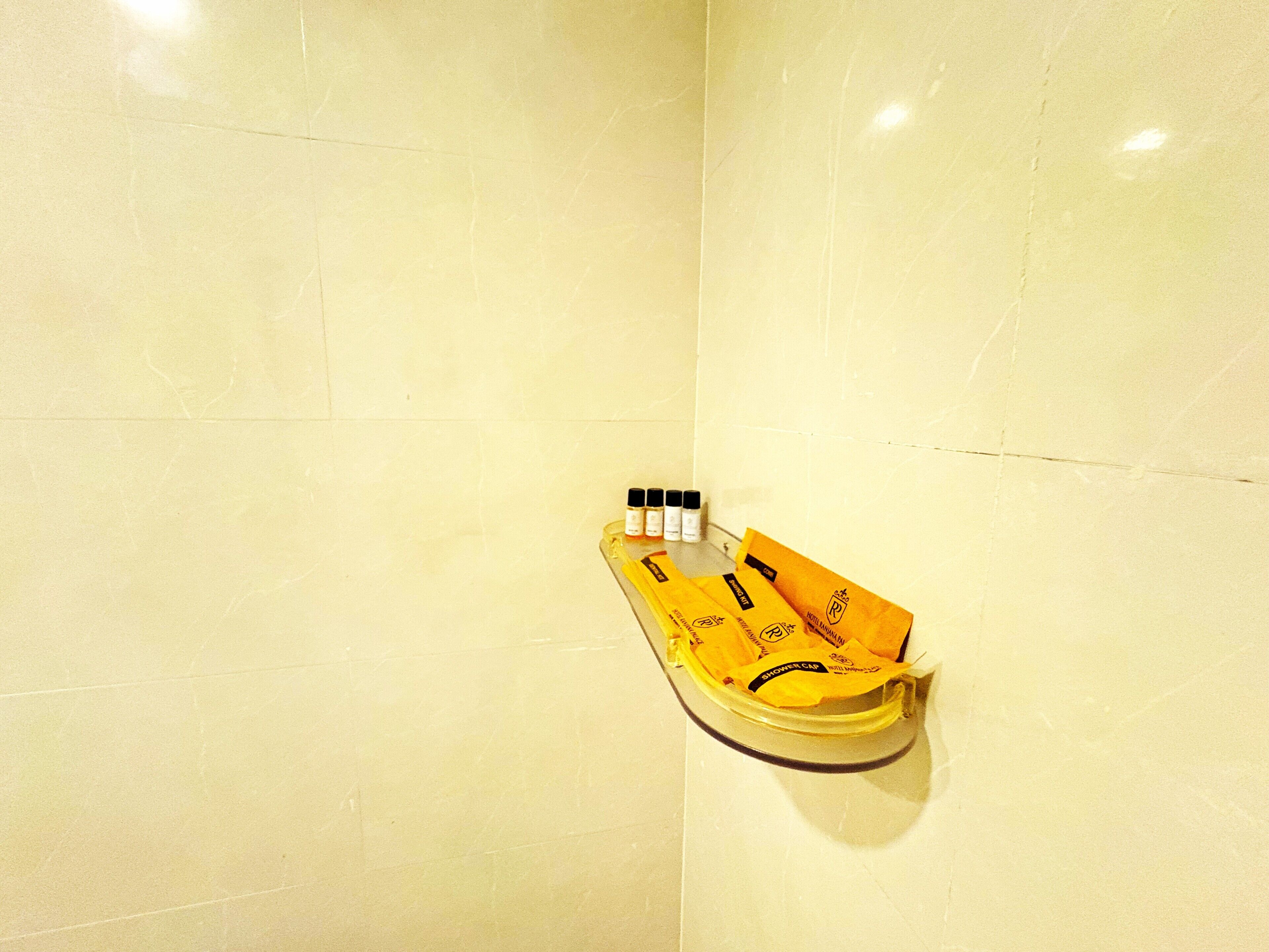 A yellow shower caddy with toiletries on a tiled wall.