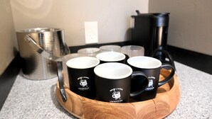 Ein Holztablett mit sechs schwarzen Tassen mit weißen Deckeln, wobei jede Tasse mit "Love Muffin Cafe" beschriftet ist.