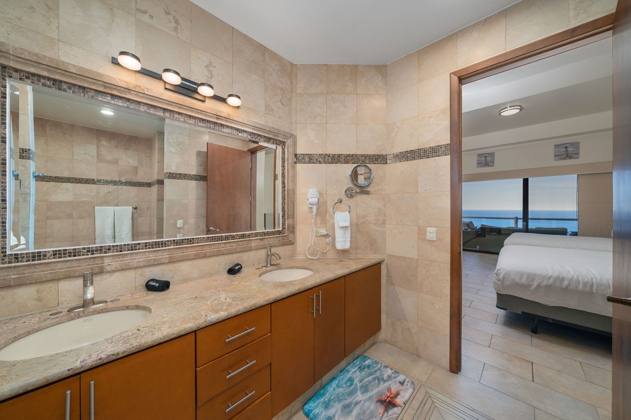 Un baño moderno con un espejo grande, lavamanos dobles y zona de ducha.