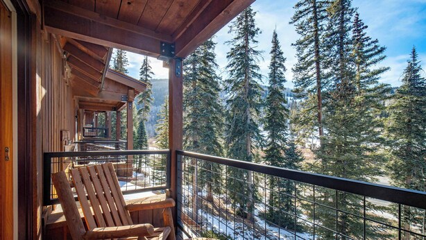 A wooden deck with a wooden chair, overlooking a snowy forest. - Black Bear 50 - Ski-In/Out Durango Townhome (Durango)