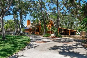 A house with a covered porch, a chimney, and a well-maintained lawn. - Tropical Backyard Oasis near Indian Rocks Beach with tons of extras. (Largo)