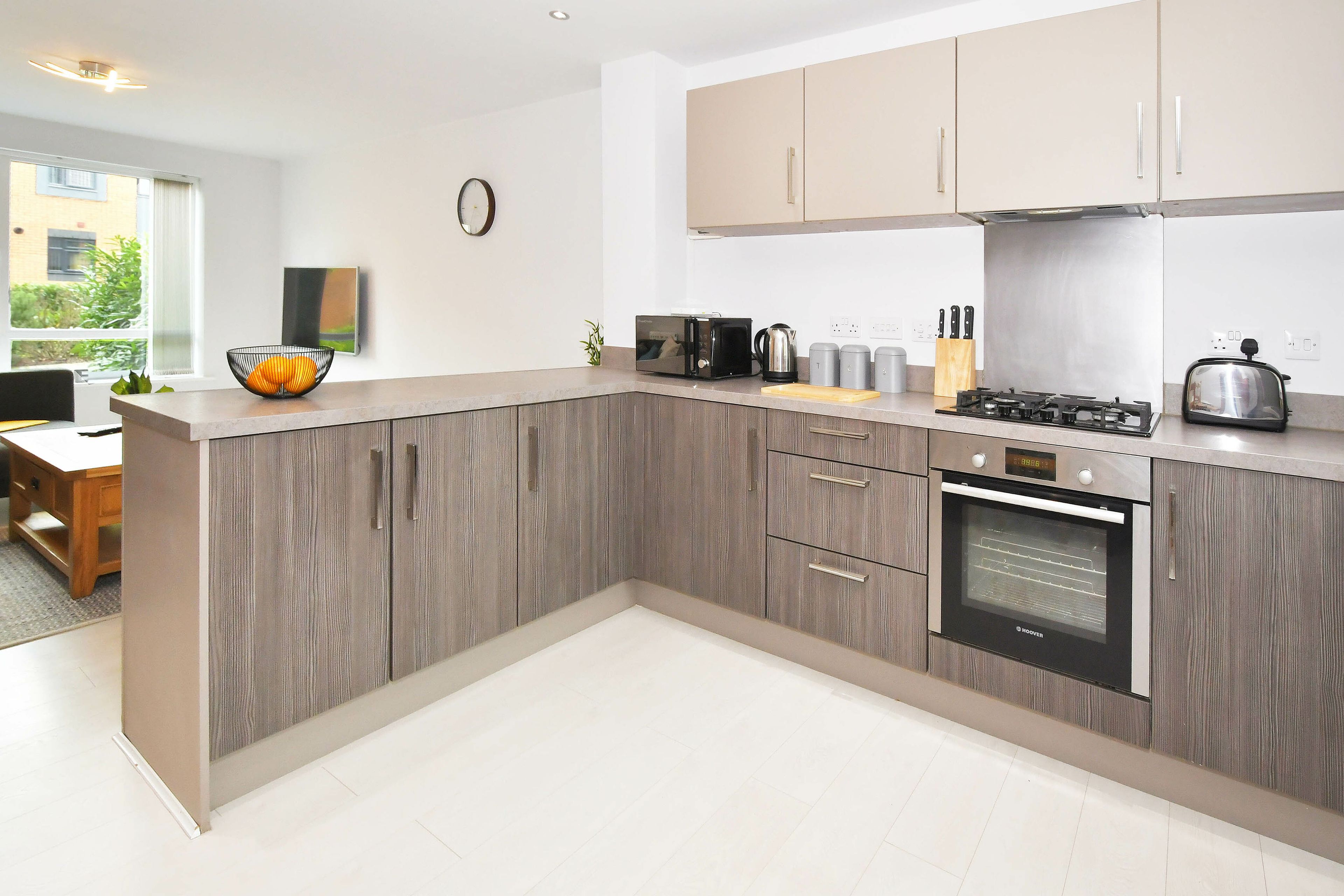 A modern kitchen with a built-in oven, a coffee maker, and a toaster.