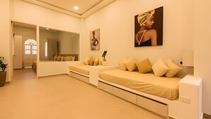 A modern hotel room with a large mirror, two beds with beige bedding, and a large window with a view of the outside. - Apt with balcony in the Historic Center - Zaher G (Cartagena)