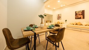 A dining area with a wooden table, four brown chairs, and a vase with a plant. - Apt with balcony in the Historic Center - Zaher G (Cartagena)
