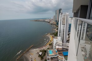 A high-rise building with a view of a curved coastline and a beach. - Luxurious 1 bd apt on the 29th floor - Morros City (Cartagena)