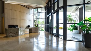 Eine moderne Lobby mit einer Rezeption, großen Fenstern und einem sauberen, polierten Boden.