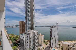 Ein Hochhaus mit Blick auf ein Gewässer und eine Stadtlandschaft im Hintergrund.