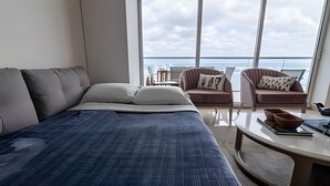 Quarto moderno com uma cama grande, dois sofás e uma mesa de centro.