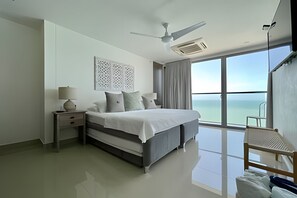 A modern bedroom with a bed, nightstand, and a chair. - Luxurious 2-bd Apt on the 20th Floor - Morros City (Cartagena)