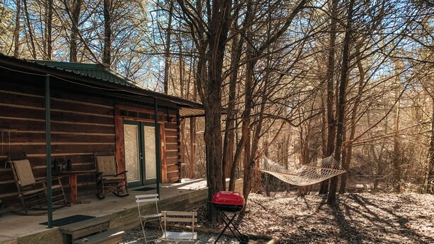 A rustic cabin with a porch, a hammock, and a red suitcase. - Green Briar Cabin a beautiful private log cabin (Marietta)