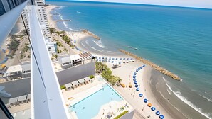 Ein Hochhaus-Hotel mit Pool und Blick auf den Strand.