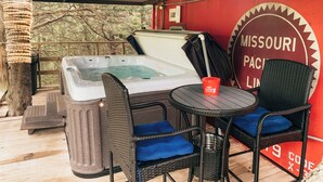 Zona de hidromasaje con sillas de mimbre, una mesa, un balde y un cartel que dice "Missouri Pacific Line".