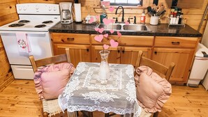 Une cuisine chaleureuse avec des meubles en bois, un poêle blanc et une machine à café.