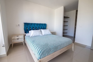 Ein Schlafzimmer mit Bett, Nachttisch und Kleiderschrank.