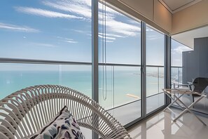 Una habitación moderna con amplios ventanales de piso a techo que ofrecen vista al océano.