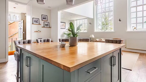 A spacious kitchen with a large island, pendant lighting, and a view of the outdoors through large windows. - Stylish Stay w/ All you Need- The Old Grammar School (Kibworth)