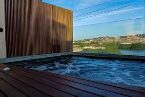 A spa area with a wooden deck and a view of a river and distant landscape. - Spectacular view of San Felipe Castle! (Cartagena)