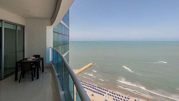 A balcony with a view of the sea, a table with chairs, and a glass wall. - Spectacular Ocean View - Ed. Infinito 2302 (Cartagena)
