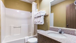 A bathroom with a bathtub, toilet, and sink. - Urban Inn & Suites (Boise)