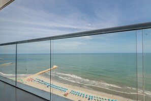 A beach view from a balcony with a clear sky, calm sea, and beach umbrellas. - 2102 Morros City - Spectacular Ocean View (Cartagena)