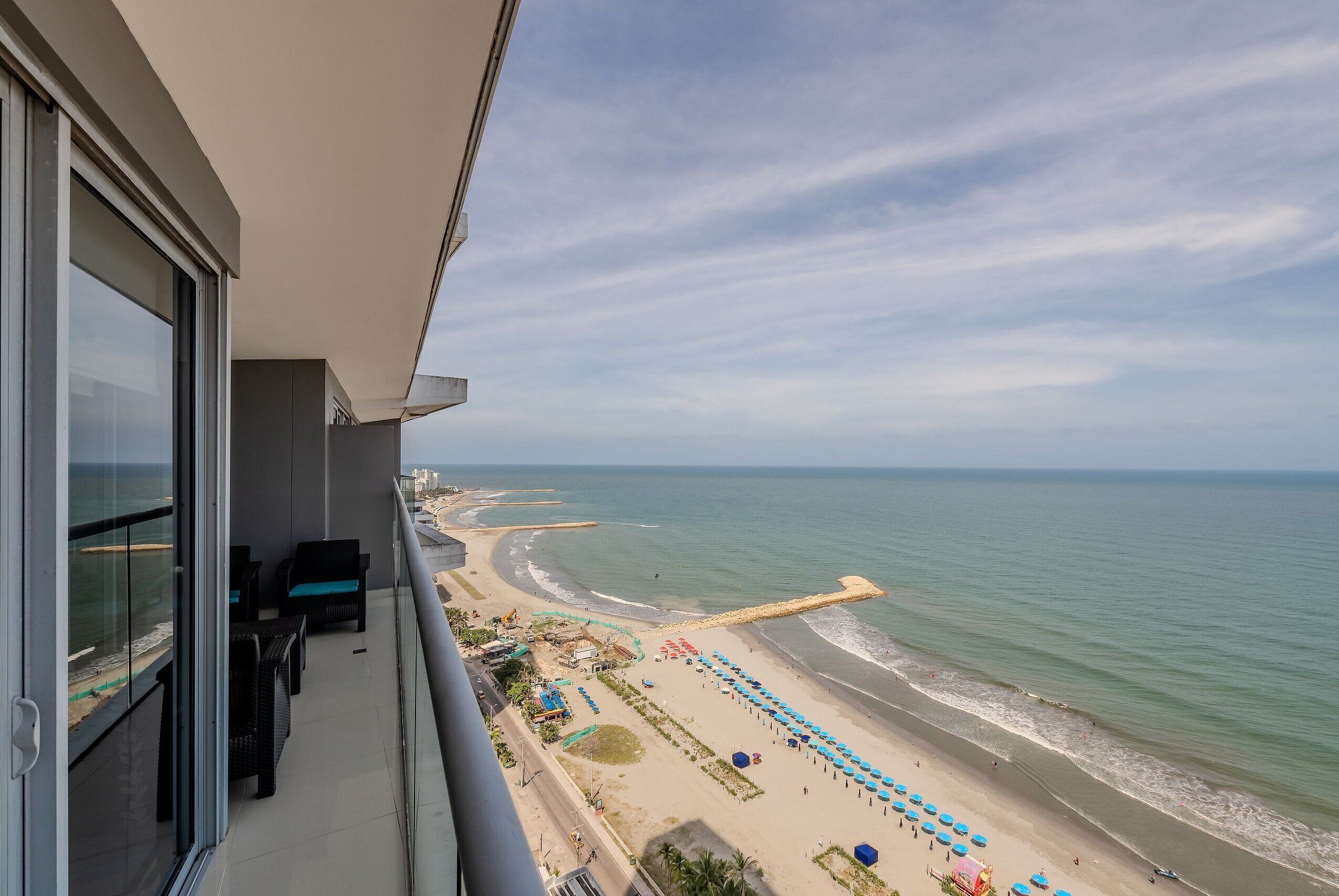 A balcony with a view of a beach and ocean.