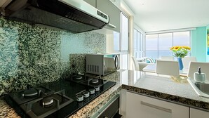Eine moderne Küche mit Gasherd, Granitarbeitsplatte und Spritzschutz mit strukturierter Musterung.