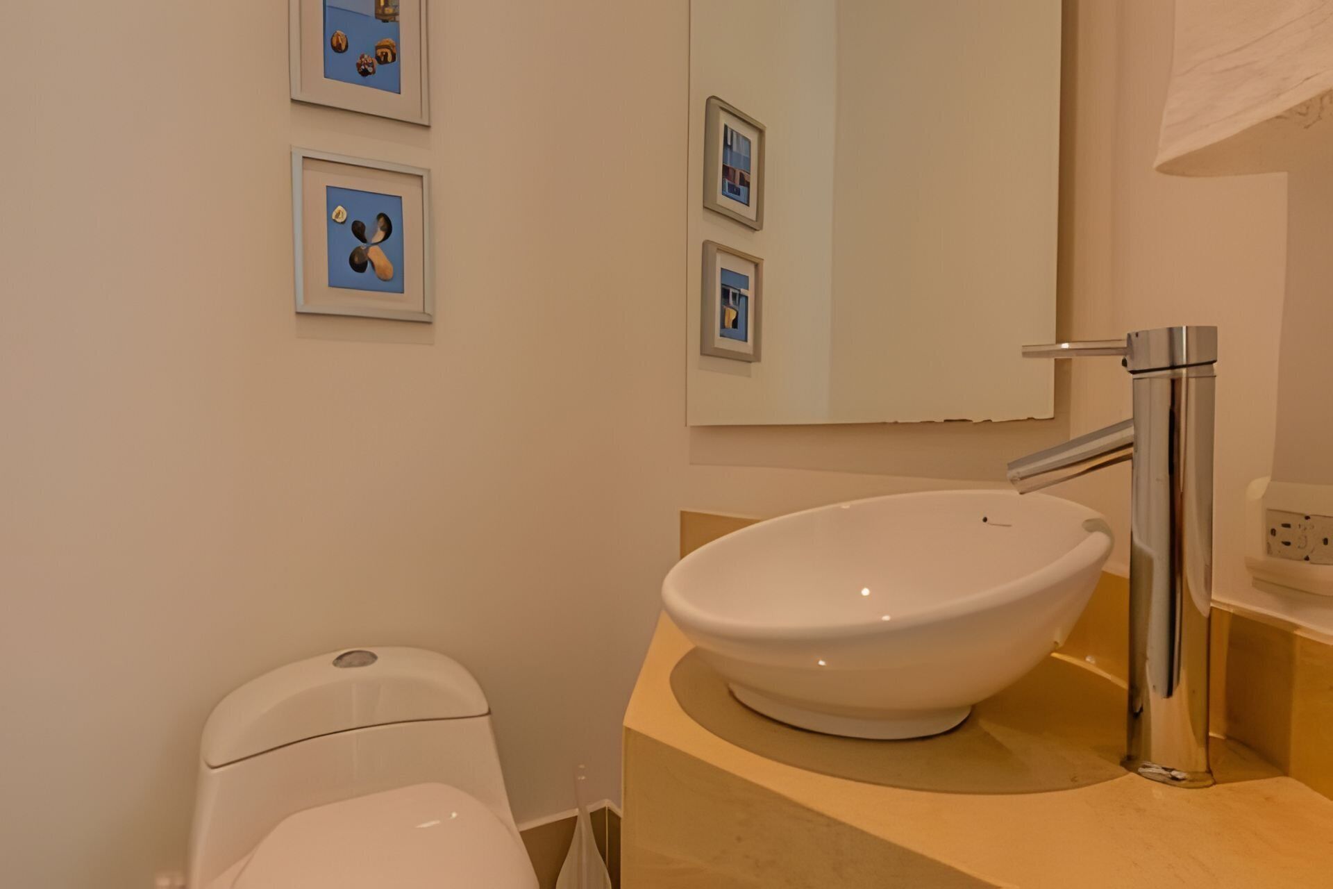 A bathroom with a white sink, a toilet, and a mirror.