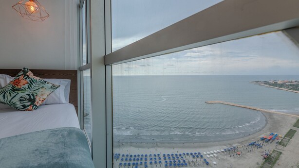 Una camera da letto con una grande finestra vista spiaggia.