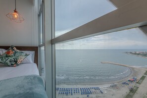 Une chambre avec une grande fenêtre donnant sur une plage.