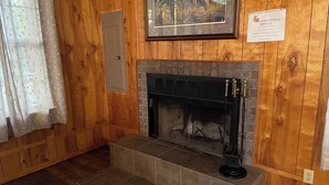 A fireplace with a tiled surround, a framed picture above it, and a sign with instructions for fireplace use. - Couples Retreat with King Canopy Bed, Jacuzzi for Two, Fireplace & Pond-View Porch (Zwolle)