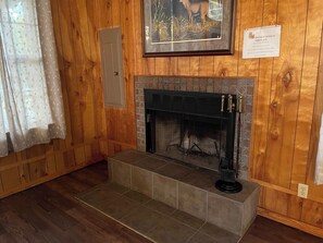 Un camino con rivestimento in piastrelle, un quadro incorniciato sopra e un cartello con le istruzioni per l'uso.