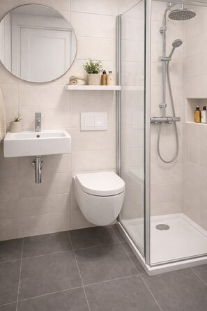 A modern bathroom with a glass-enclosed shower, a white sink, and a toilet. - Landhotel Schwarzer Adler (Staffelstein)