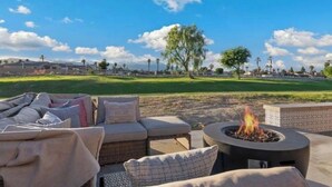 Un patio con mobiliario exterior y una chimenea.