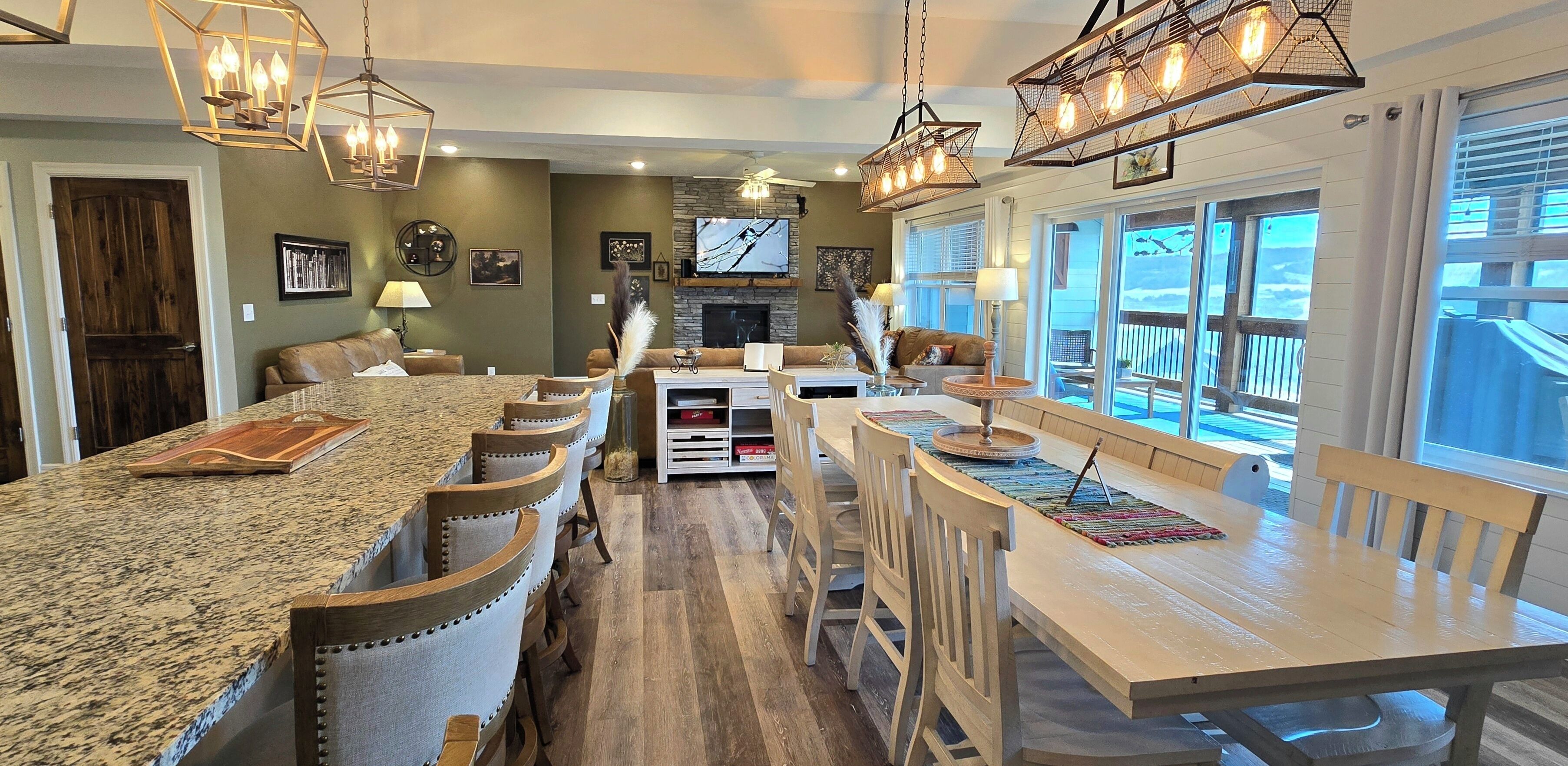 A spacious living area with a large island, multiple seating arrangements, and a fireplace.