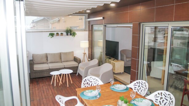 Un espace extérieur aménagé avec une table à manger, un canapé et des chaises.