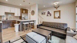 A modern apartment with a kitchen, dining area, and living room.