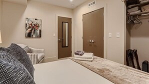 Une chambre à coucher avec un lit, une armoire, un tableau et un miroir.