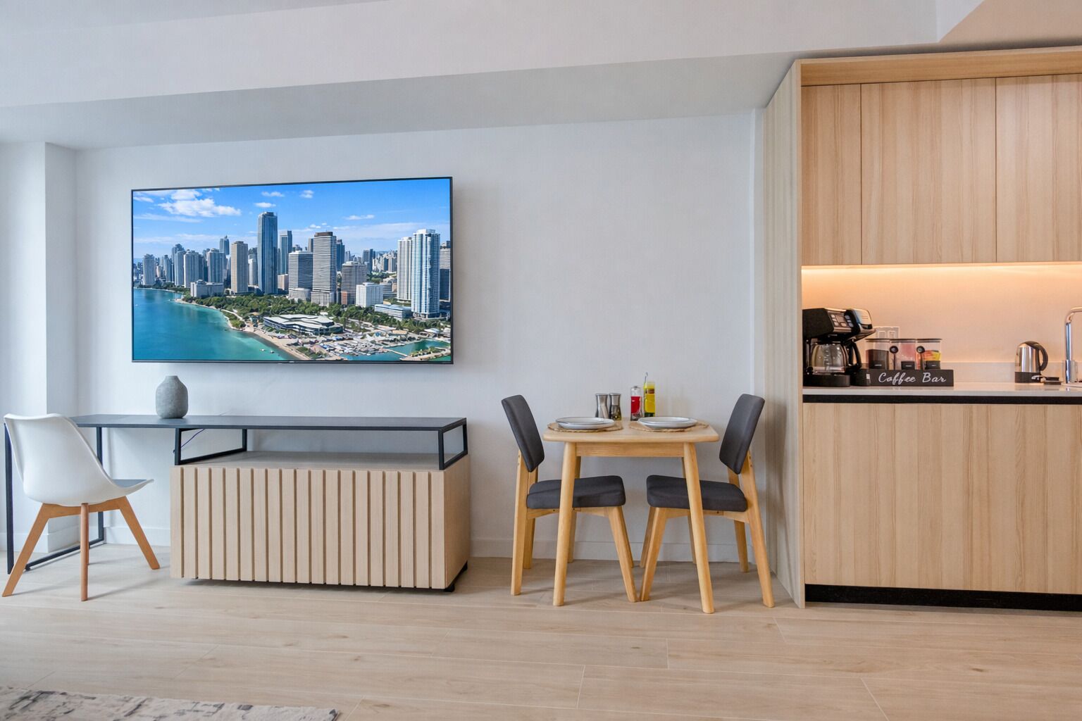 Un salon moderne comprenant un coin repas, un bar à café et un grand tableau représentant un paysage urbain accroché au mur.