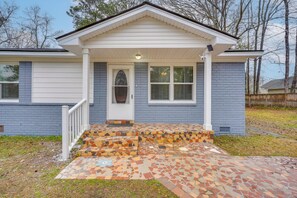 A house with a front porch, a door, and a small set of steps leading to the entrance. - Near Citadel Mall! Extended Getaway 8 Mi to Dtwn (Charleston)