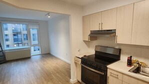 A modern kitchen with a built-in stove, oven, and microwave. There is a window with a view of a building outside. - Long term,1 bdr/apt in BRKL Barklay Ctr,move-out Oct1st, availableNOW,3,450month (Brooklyn)