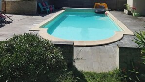 Una piscina rettangolare con un bordo piastrellato tutt'intorno.
