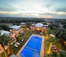 Un resort con piscina, varias habitaciones y un jardín exuberante.