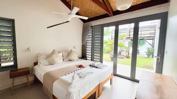 A bedroom with a bed, a ceiling fan, a window, and a view of the outdoors.