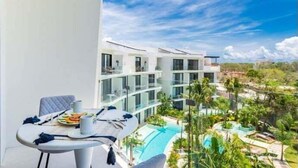 A modern hotel with a pool area, outdoor seating, and a view of the surrounding landscape.
