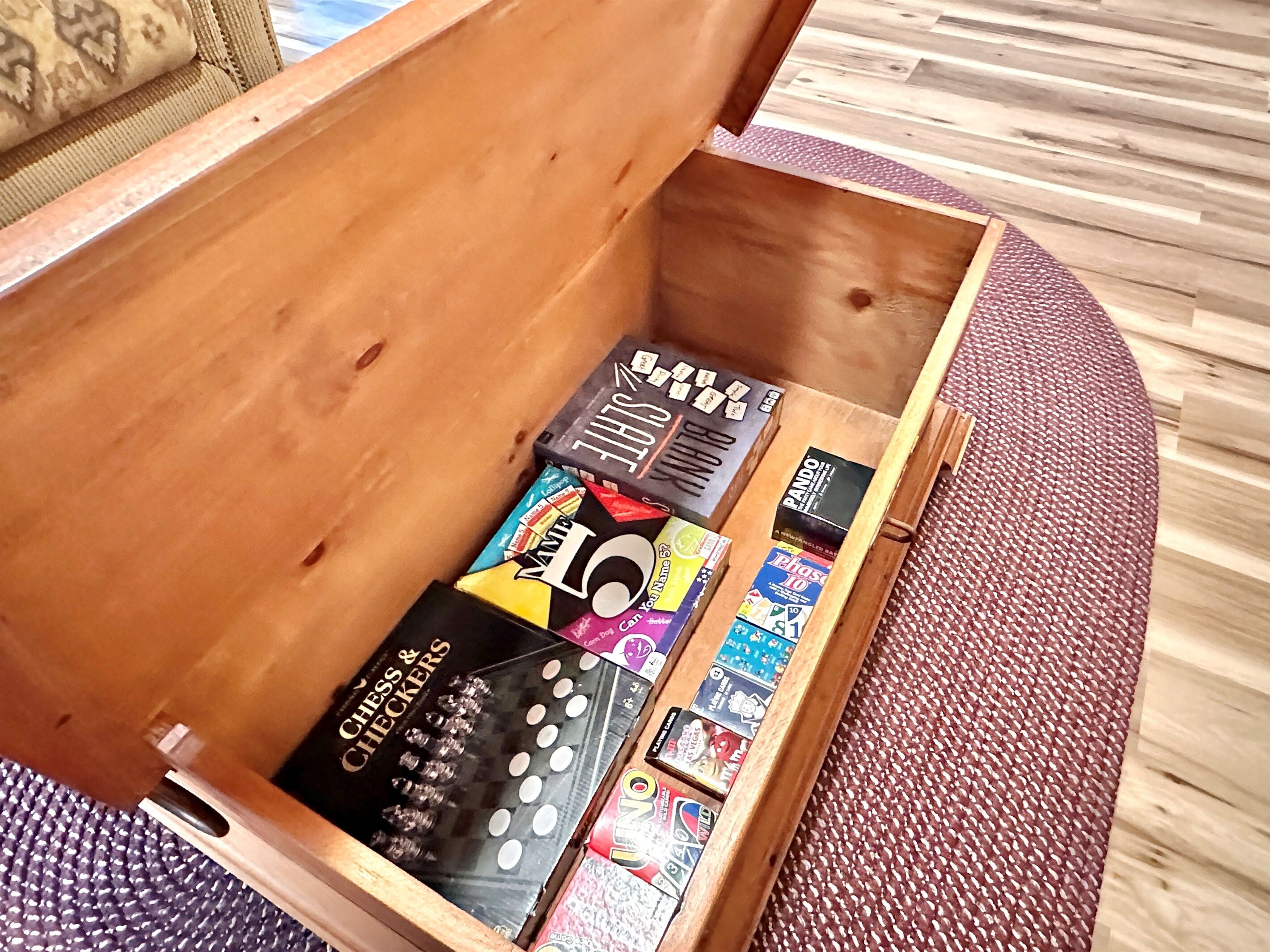A wooden chest with various board games and cards.