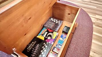 A wooden chest with various board games and cards.