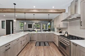 Una cocina moderna con vigas de madera, electrodomésticos de acero inoxidable y una isla grande.